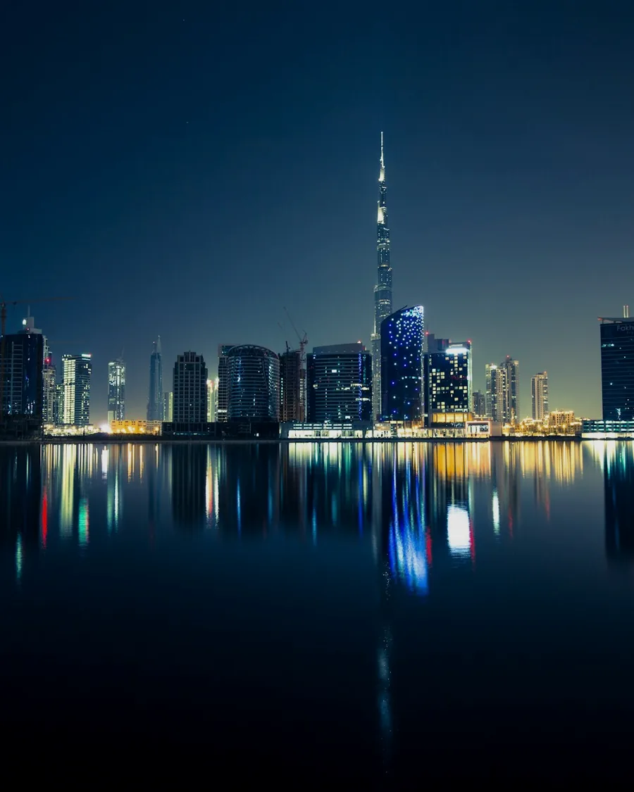 The Dubai skyline reflected in still water at night